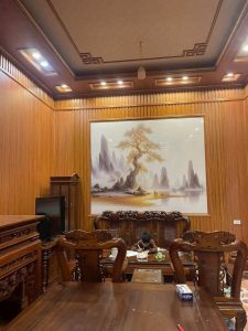 Không gian phòng khách sau khi hoàn thiện tấm Nano vân gỗ, kết hợp với bộ bàn ghế gỗ và mảng tranh trang trí lớn