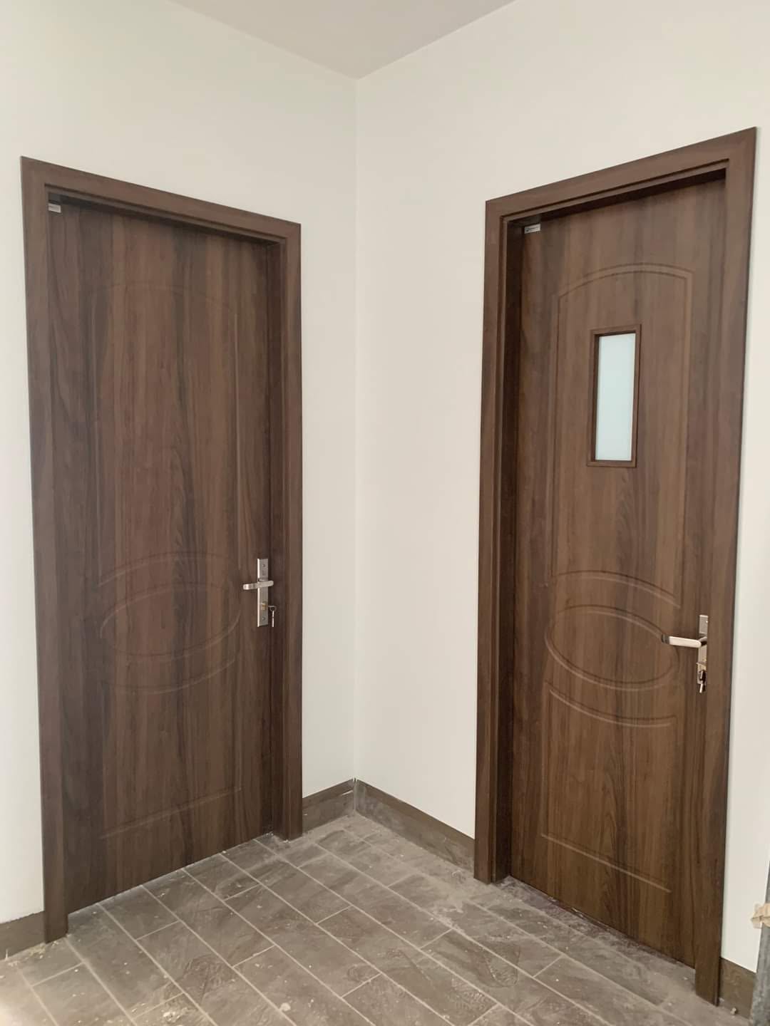Hai cửa composite vân gỗ nâu lắp tại góc hành lang nhà mặt phố Lạc Long Quân